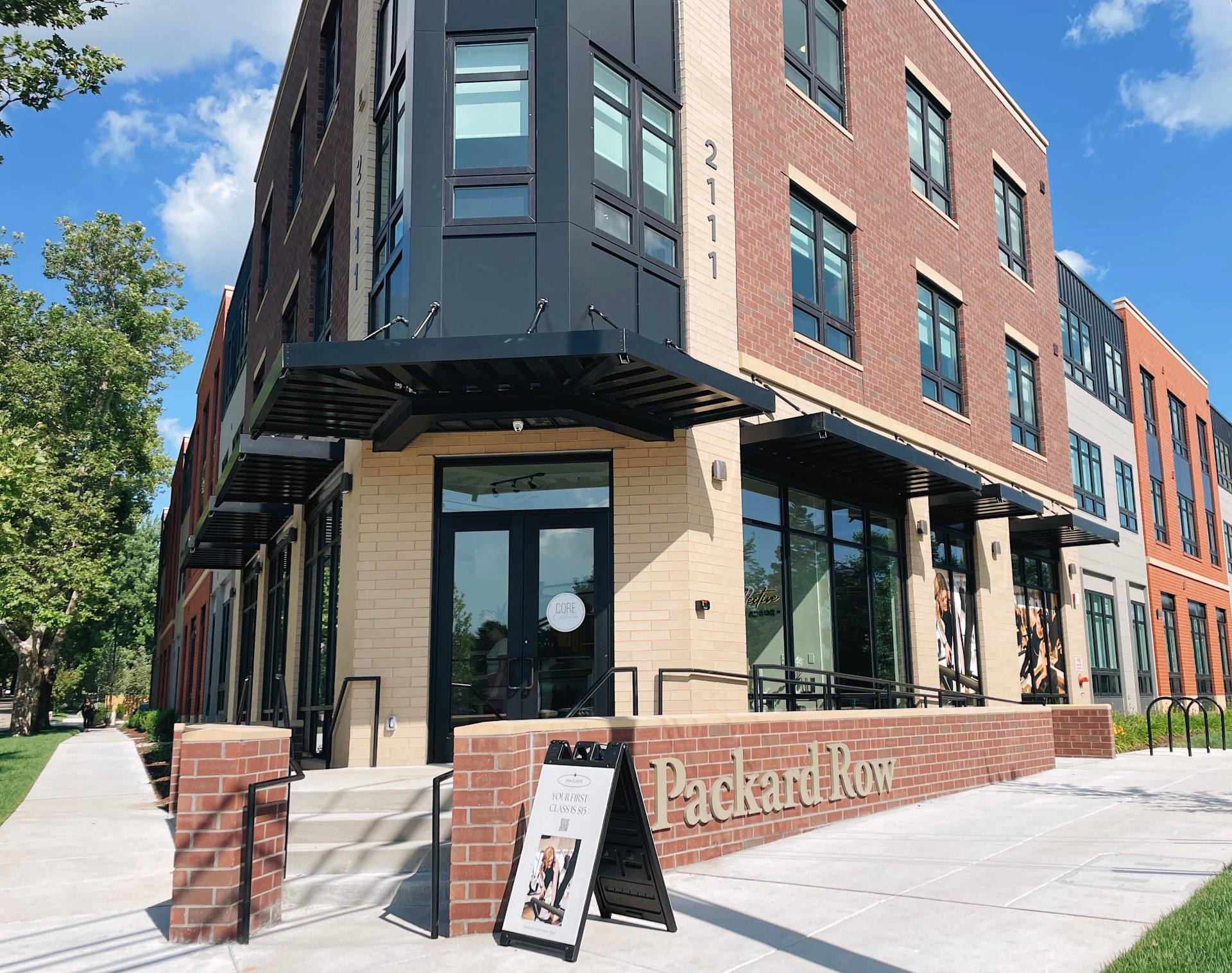 The Packard Row building exterior with Core Collective signage and parking