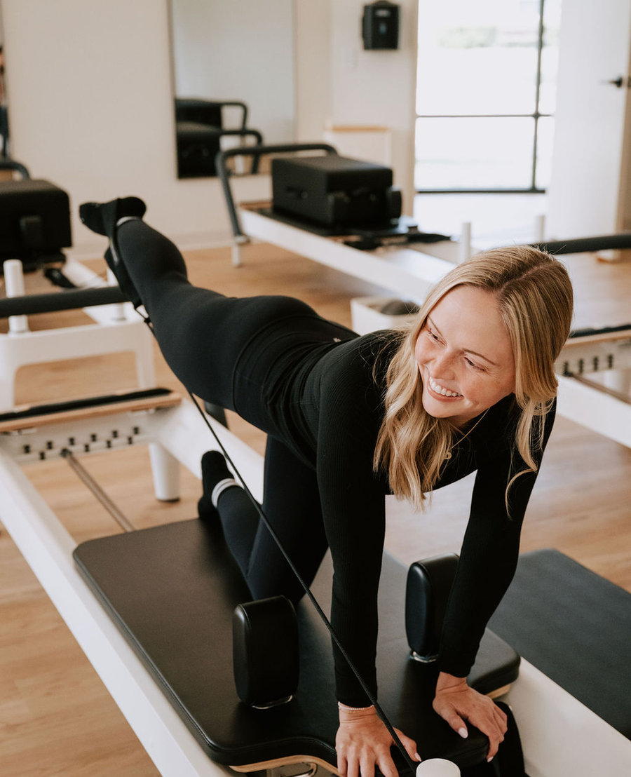 A Reformer class working through upper body exercises