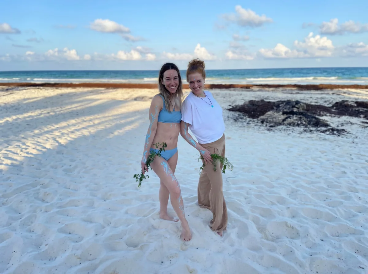 Two Core Collective members posing together on the beach during the Tulum retreat in Mexico