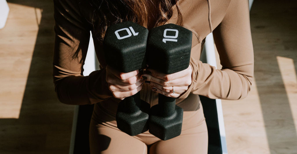 A pair of ten-pound dumbbells on the floor of the strength area
