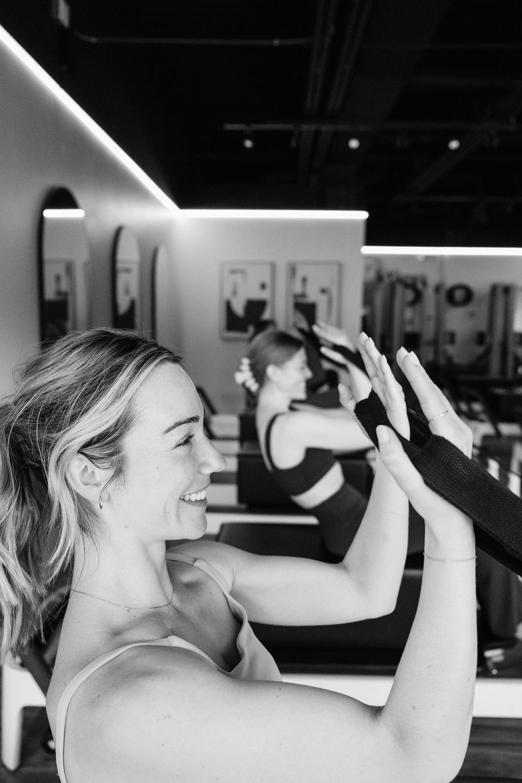 Smiling member in a Core Collective Plymouth Road Reformer class