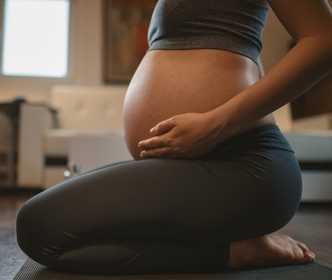 Pregnant client working with an instructor at the prenatal Pilates workshop