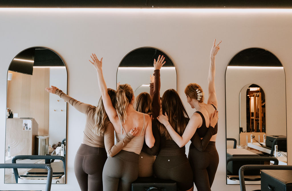 Group of clients celebrating together in the bright Ann Arbor studio after class